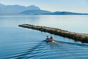 An unidentified fisherman in his traditional wooden boat leaves the harbour in Amvrakikos gulf, going to work.