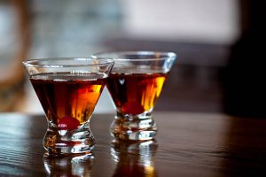 Two Manhattan cocktails on wooden table. Two Manhattan cocktails on wooden table.
