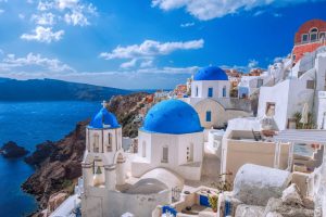 Oia village in Santorini island with churches,  Greece