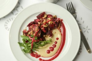 Beetroot salad served with hummus and fresh arugula