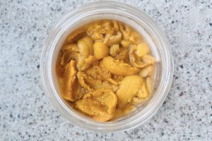 caviar of sea urchin fish, small in a glass plastic jar with a lid, open